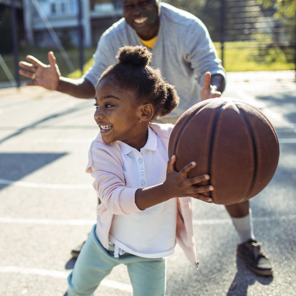 Young girl smiling playing basketball