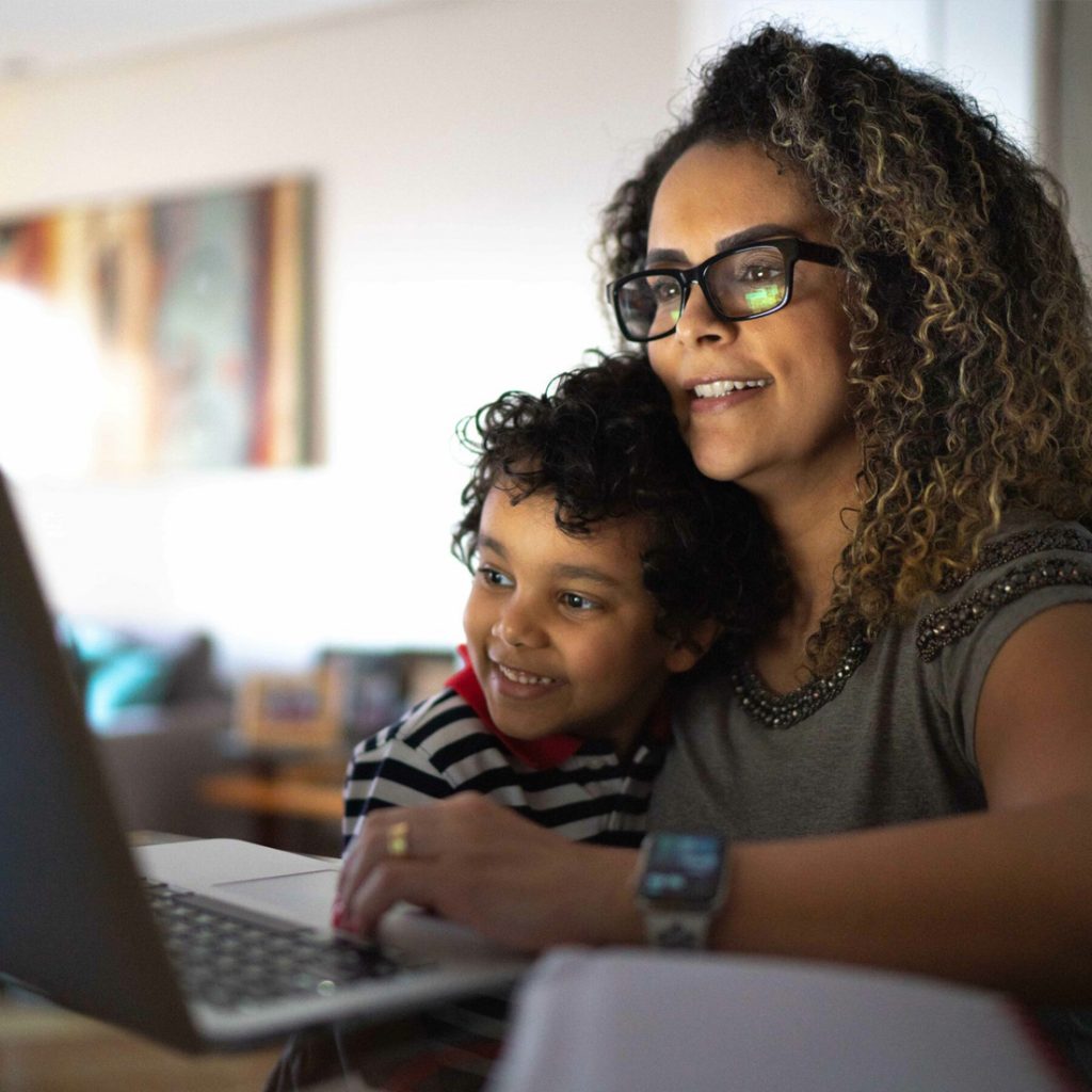 Woman with a boy on her lap looking at a laptop